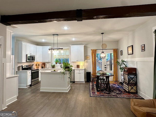 kitchen featuring decorative light fixtures, stainless steel appliances, and white cabinetry