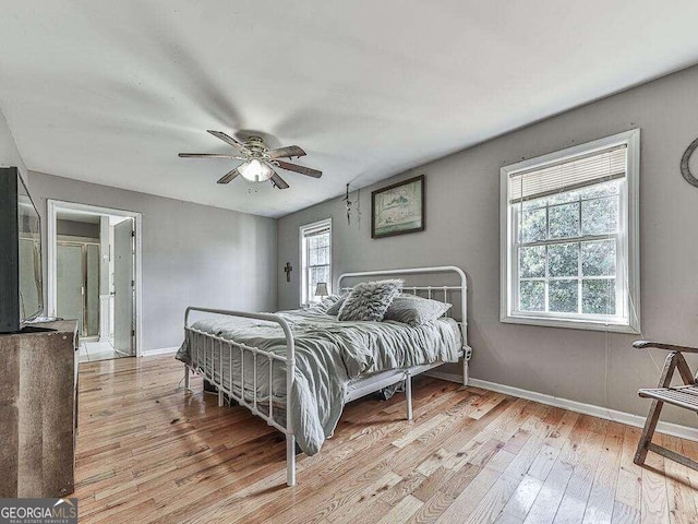 bedroom featuring light wood-type flooring, multiple windows, and ceiling fan