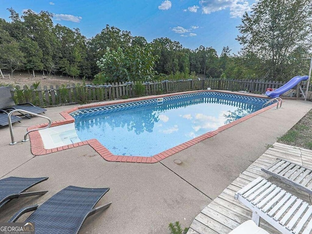 view of swimming pool featuring a water slide and a patio