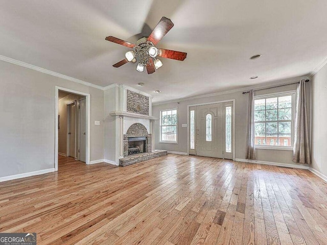 unfurnished living room with ceiling fan, a stone fireplace, crown molding, and light hardwood / wood-style floors