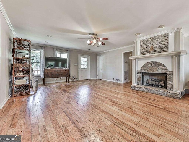 unfurnished living room featuring ceiling fan, a fireplace, crown molding, and wood-type flooring