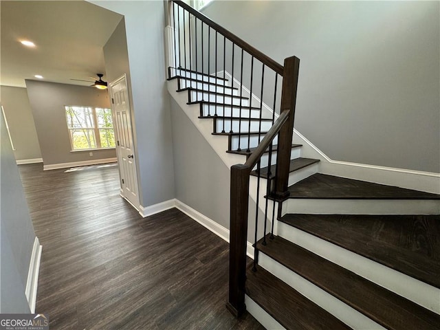 staircase with hardwood / wood-style floors and ceiling fan