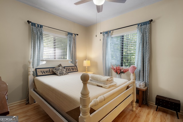 bedroom featuring wood-type flooring, multiple windows, and ceiling fan