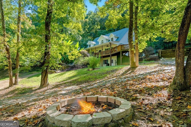 view of yard featuring a deck and an outdoor fire pit