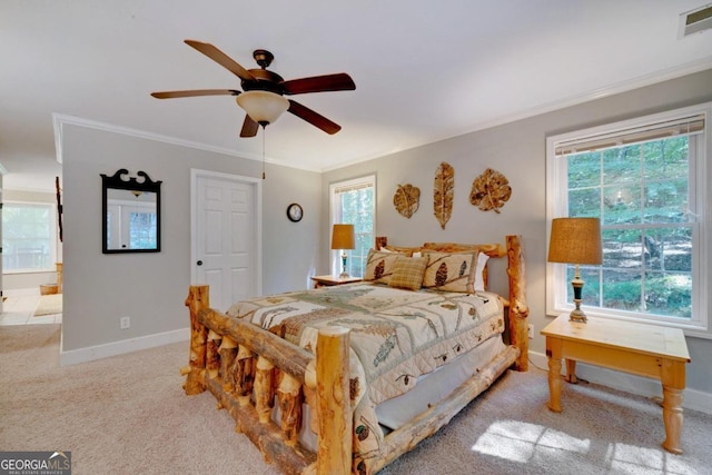 carpeted bedroom featuring crown molding, ensuite bath, and ceiling fan