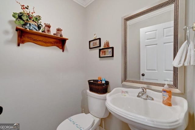 bathroom featuring ornamental molding, sink, and toilet