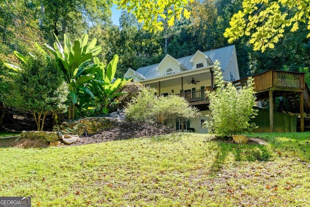 view of yard with ceiling fan and a deck