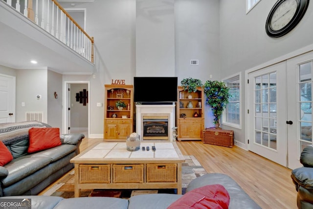 living room featuring light hardwood / wood-style floors and a high ceiling