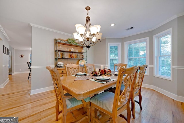 dining room with light hardwood / wood-style flooring, a chandelier, and crown molding