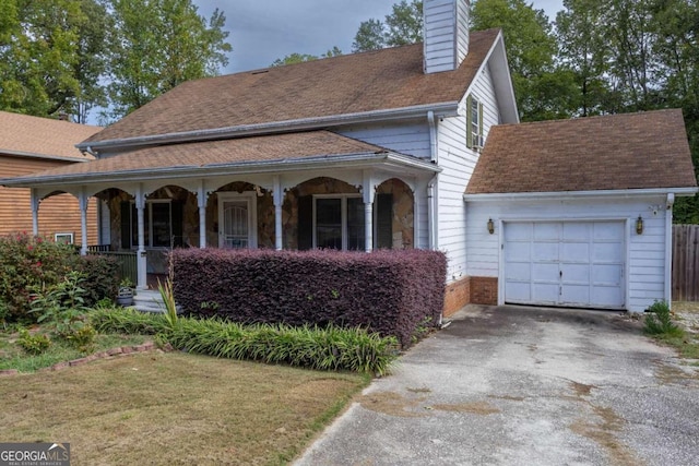 view of front of property featuring covered porch, a front yard, and a garage