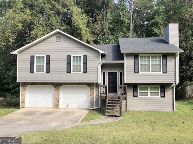 split foyer home featuring a garage and a front yard