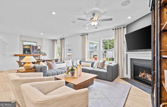 living room featuring light hardwood / wood-style floors, a healthy amount of sunlight, and ceiling fan