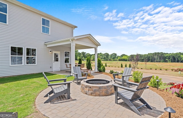 view of patio with an outdoor fire pit and a rural view