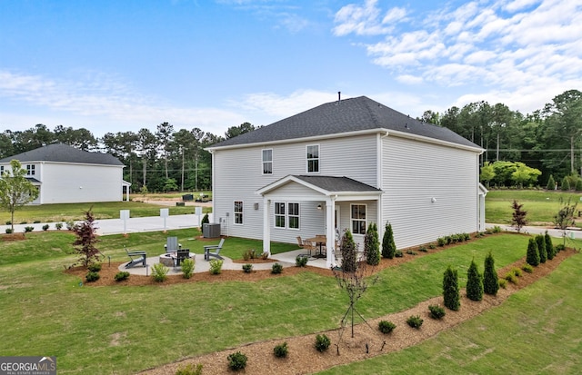 view of front facade featuring a patio, a front lawn, and central AC unit