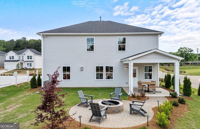 back of property featuring a patio, an outdoor fire pit, and a yard