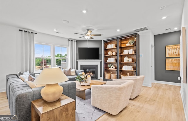 living room featuring light hardwood / wood-style flooring and ceiling fan