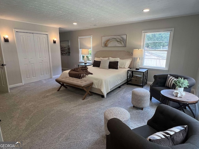 carpeted bedroom with a textured ceiling and a closet