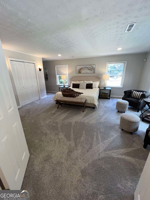 carpeted bedroom featuring a closet and a textured ceiling