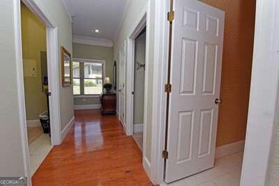 hall with light wood-type flooring and crown molding