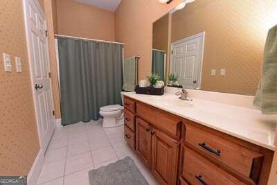 bathroom featuring tile patterned flooring, vanity, and toilet