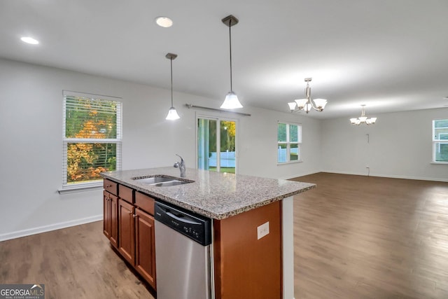 kitchen featuring dishwasher, sink, a notable chandelier, a center island with sink, and hardwood / wood-style flooring