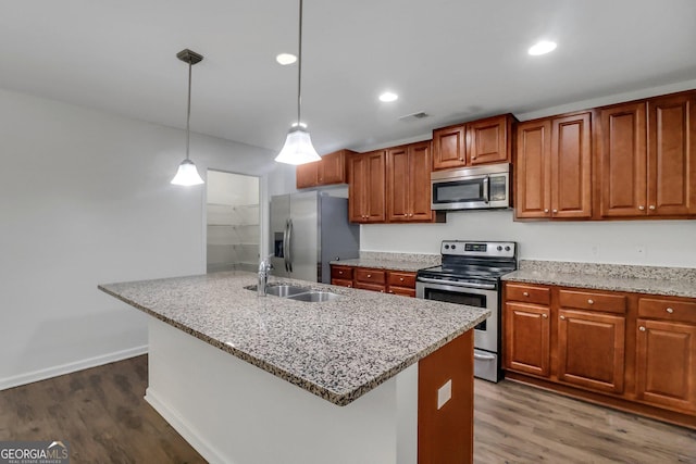 kitchen with appliances with stainless steel finishes, dark hardwood / wood-style floors, pendant lighting, and sink