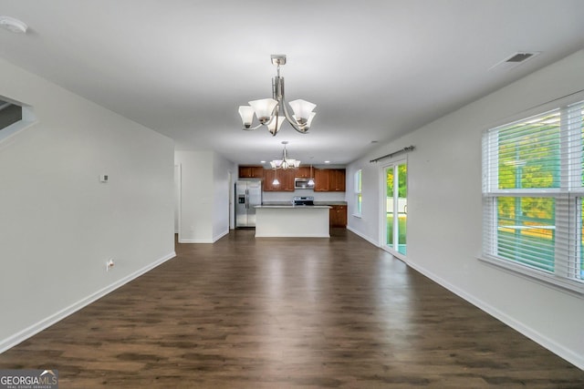 unfurnished living room with dark hardwood / wood-style floors and a notable chandelier