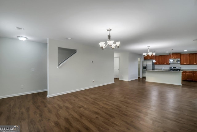 unfurnished living room with a chandelier and dark hardwood / wood-style flooring