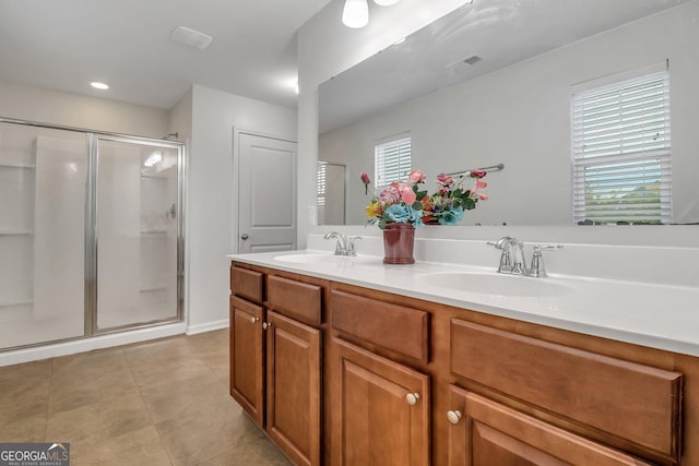 bathroom with tile patterned flooring, vanity, and a shower with shower door