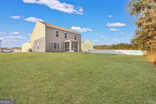 back of house with a sunroom and a yard