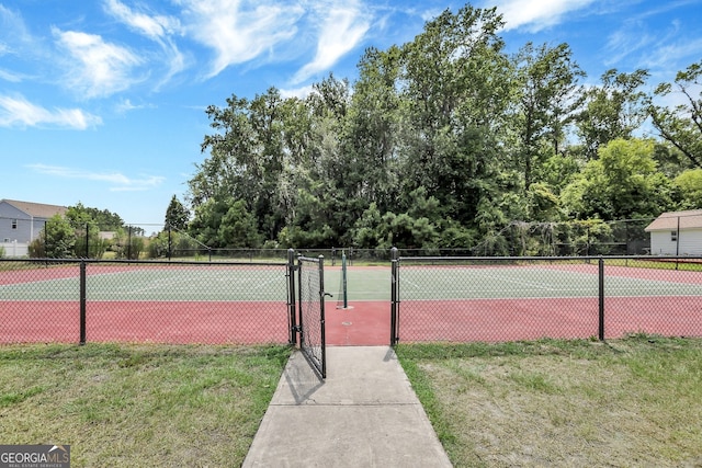 view of tennis court featuring a lawn