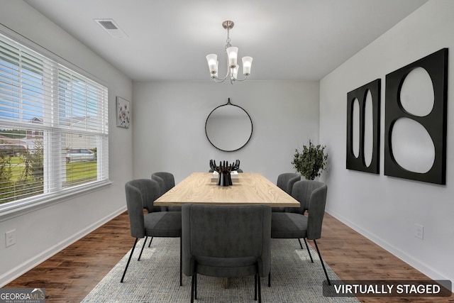 dining room featuring an inviting chandelier and dark wood-type flooring