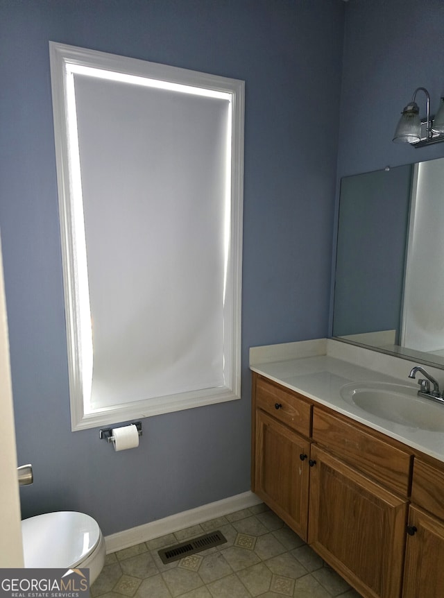 bathroom featuring tile patterned floors, vanity, and toilet