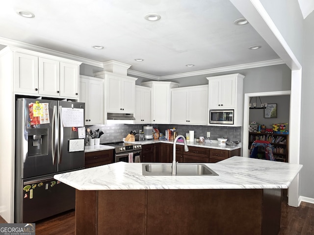 kitchen featuring dark wood-type flooring, tasteful backsplash, a kitchen island with sink, sink, and appliances with stainless steel finishes