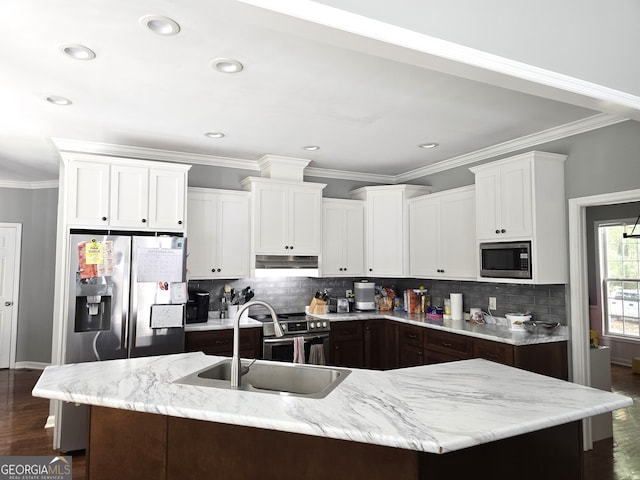 kitchen with a kitchen island with sink, dark hardwood / wood-style flooring, sink, and stainless steel appliances