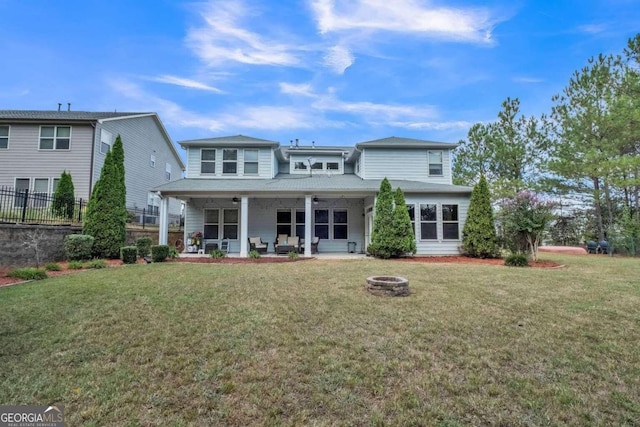 rear view of house with a lawn, a patio, and an outdoor fire pit