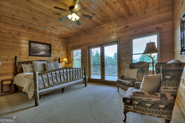 carpeted bedroom with wooden ceiling and wooden walls