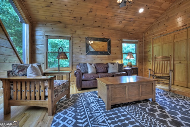 unfurnished living room featuring an inviting chandelier, a high ceiling, wood walls, and wood-type flooring