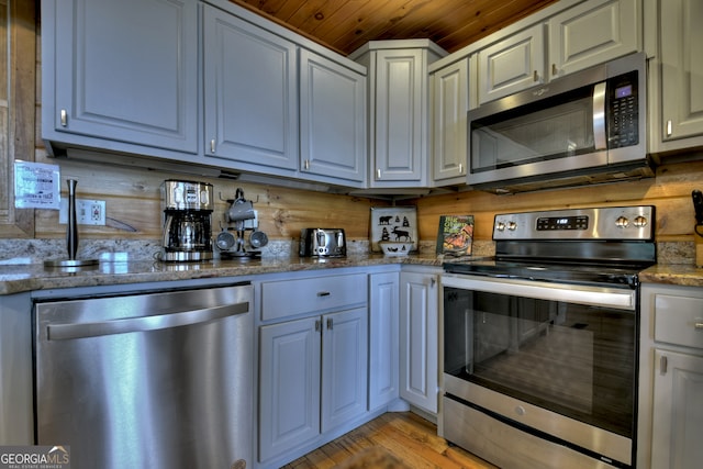 kitchen with light hardwood / wood-style floors, sink, white cabinets, appliances with stainless steel finishes, and light stone countertops