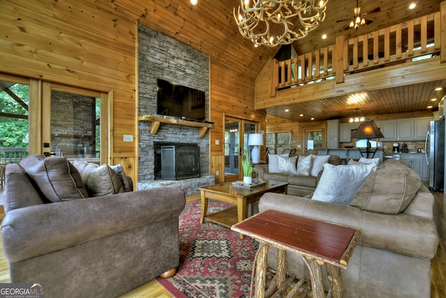 living room with wood ceiling, ceiling fan with notable chandelier, a fireplace, high vaulted ceiling, and hardwood / wood-style floors