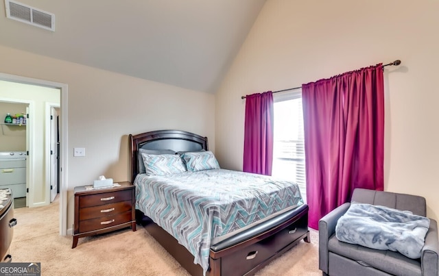 bedroom featuring light carpet, washer / clothes dryer, and high vaulted ceiling