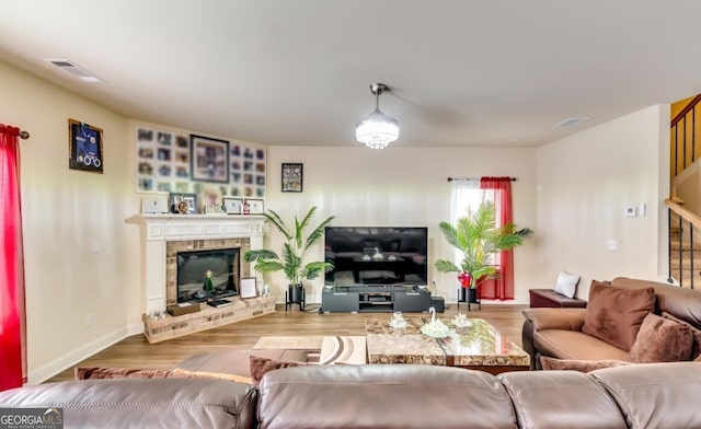 living room featuring a brick fireplace and light hardwood / wood-style floors