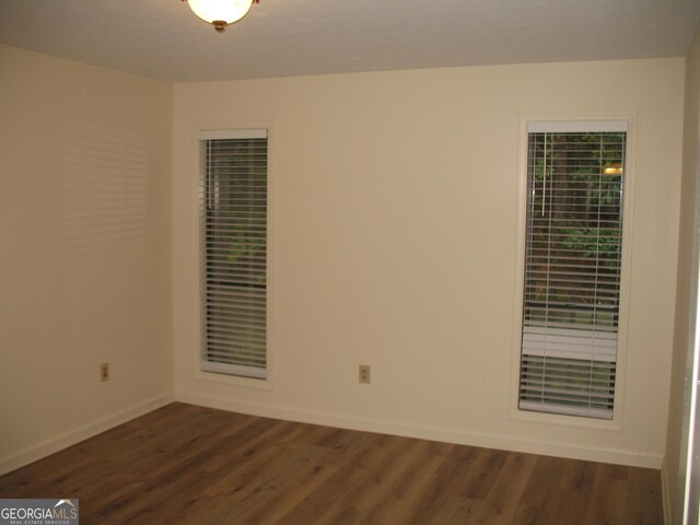 unfurnished room featuring dark hardwood / wood-style flooring