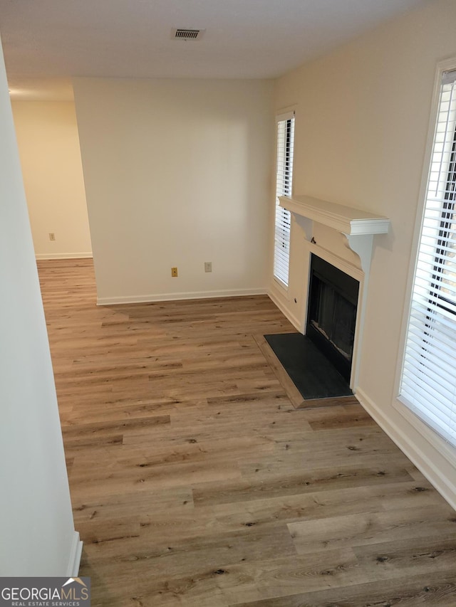 unfurnished living room featuring hardwood / wood-style flooring and plenty of natural light