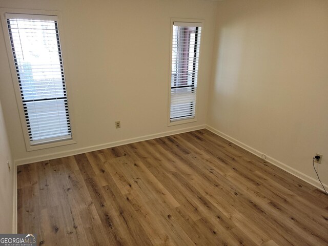 unfurnished room with hardwood / wood-style floors