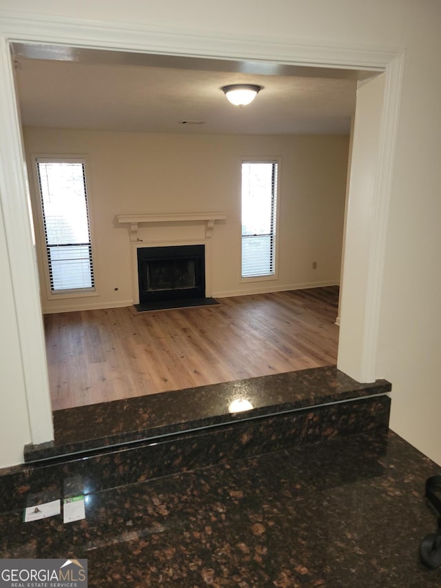 unfurnished living room featuring a healthy amount of sunlight and light hardwood / wood-style floors