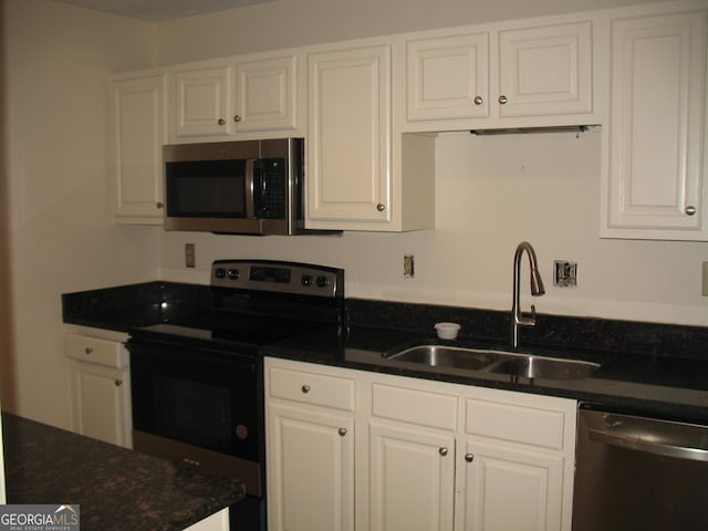 kitchen with stainless steel appliances, white cabinetry, and sink