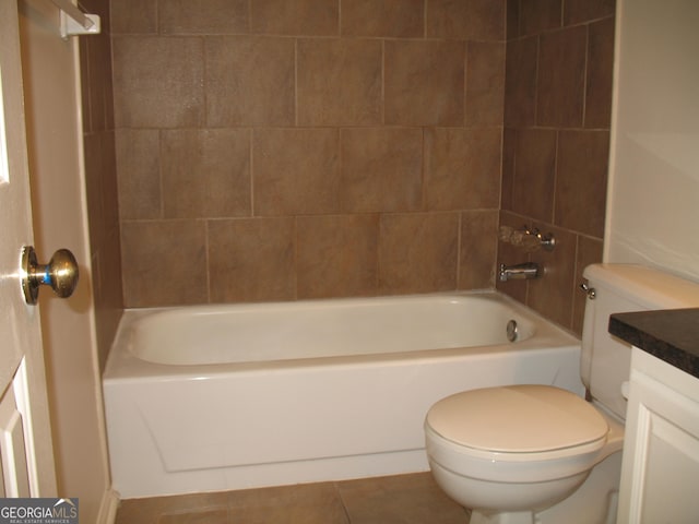 full bathroom with toilet, tile patterned flooring, tiled shower / bath, and vanity