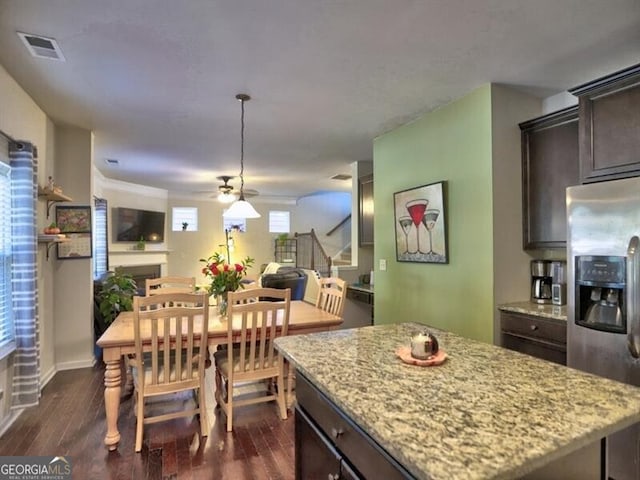 kitchen featuring dark brown cabinets, a kitchen island, dark wood-type flooring, and stainless steel refrigerator with ice dispenser