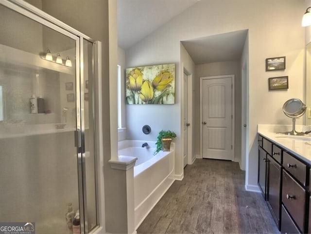 bathroom with hardwood / wood-style flooring, vanity, separate shower and tub, and lofted ceiling